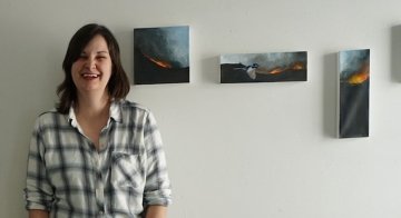 TCC Faculty Member Katherine Eagle Poses with her paintings