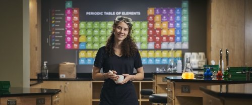 woman in front of periodic table