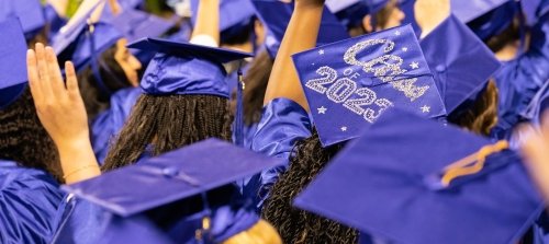 A sea of blue graduation caps. One reads, "Class of 2023."