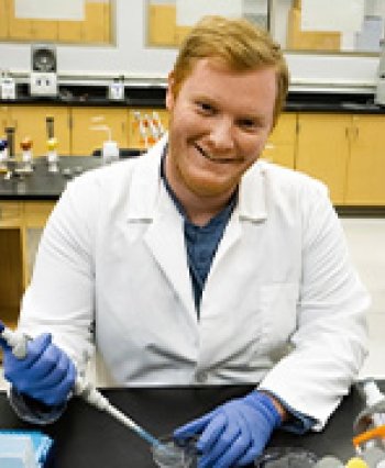 TCC Transfer Student Jarrett Stites holds a pipet in biology lab.