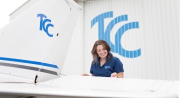 Nikki Myers stands next to a plane at the TCC Riverside Community Campus and Aviation Center.