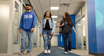 Three students walking down a hallway