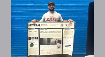 Jonathan Ford holds up his project presentation