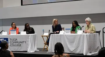 Dr. Ebony Johnson, Dr. Regina Lewis, Michelle Linn, and Dr. Tiffany Crutcher listen as Susan Savage speaks at the panel discussion.