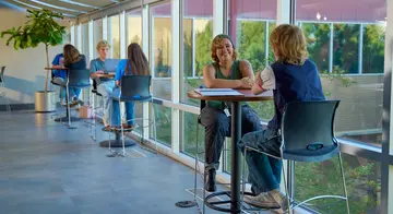 Two students sit at table and converse in TCC's Southeast Campus Student Union.