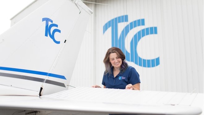 Nikki Myers stands next to a plane at the TCC Riverside Community Campus and Aviation Center.