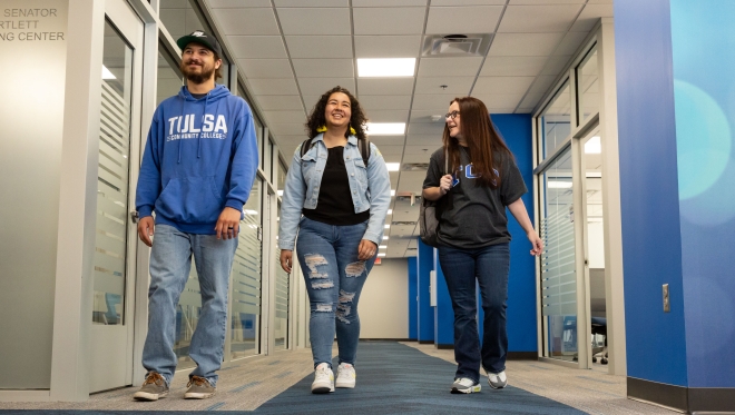 Three students walking down a hallway