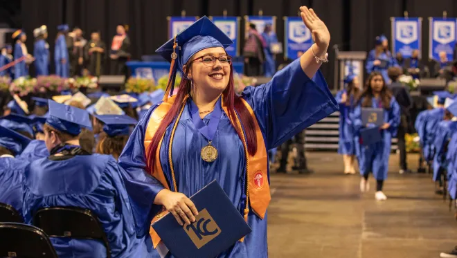 Shenoah Lyons waves after she receives her degree
