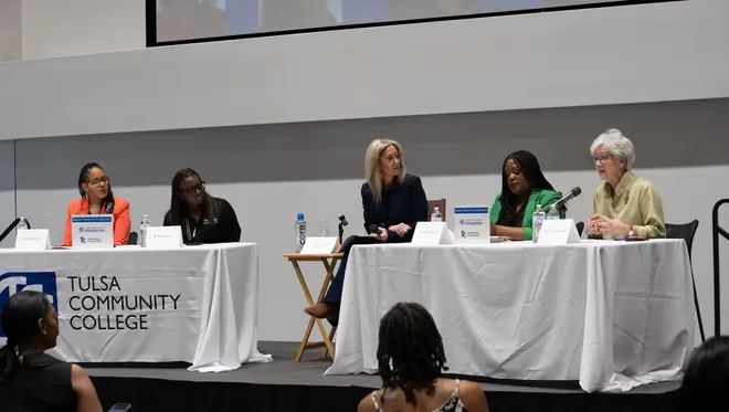 Dr. Ebony Johnson, Dr. Regina Lewis, Michelle Linn, and Dr. Tiffany Crutcher listen as Susan Savage speaks at the panel discussion.