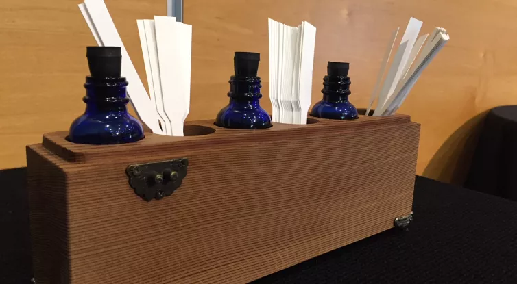 Picture of blue glass bottles that contain different scents and paper strips to place the scent on in which to smell.