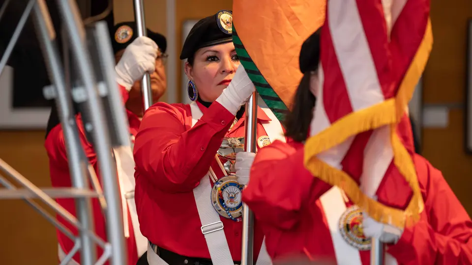Three members of the Cherokee Native Veterans Color Guard hold up flags.