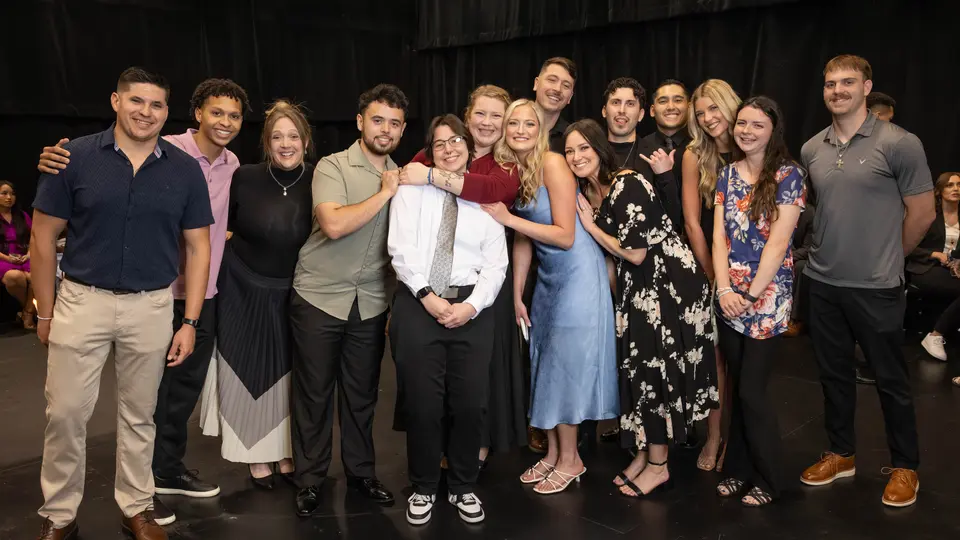 A large group of students are posing and smiling before the ceremony.