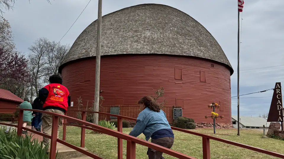 Two people walk up stairs outside the Round Barn