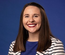 TCC Admission Counselor Lydia Mauldin smiles with long brown hair and blue shirt with striped sweater.