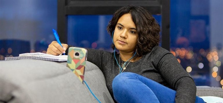 TCC student listening to online class on the phone while taking notes