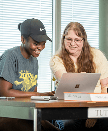 Math tutor helps young female tcc student.